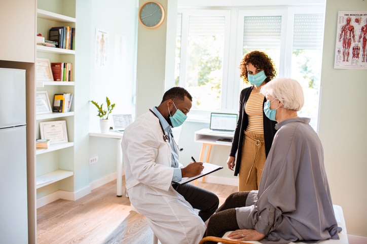 A doctor speaks with an elder patient and her daughter