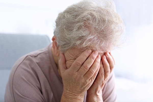 Older woman, covering face and crying
