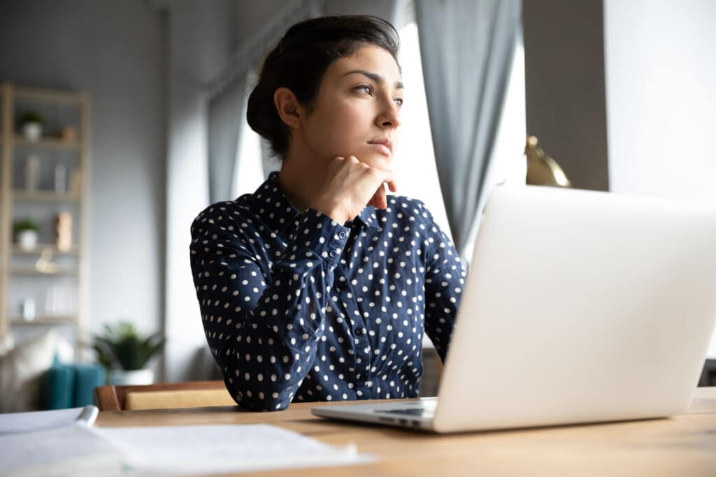 A woman working remotely with a laptop in front of her