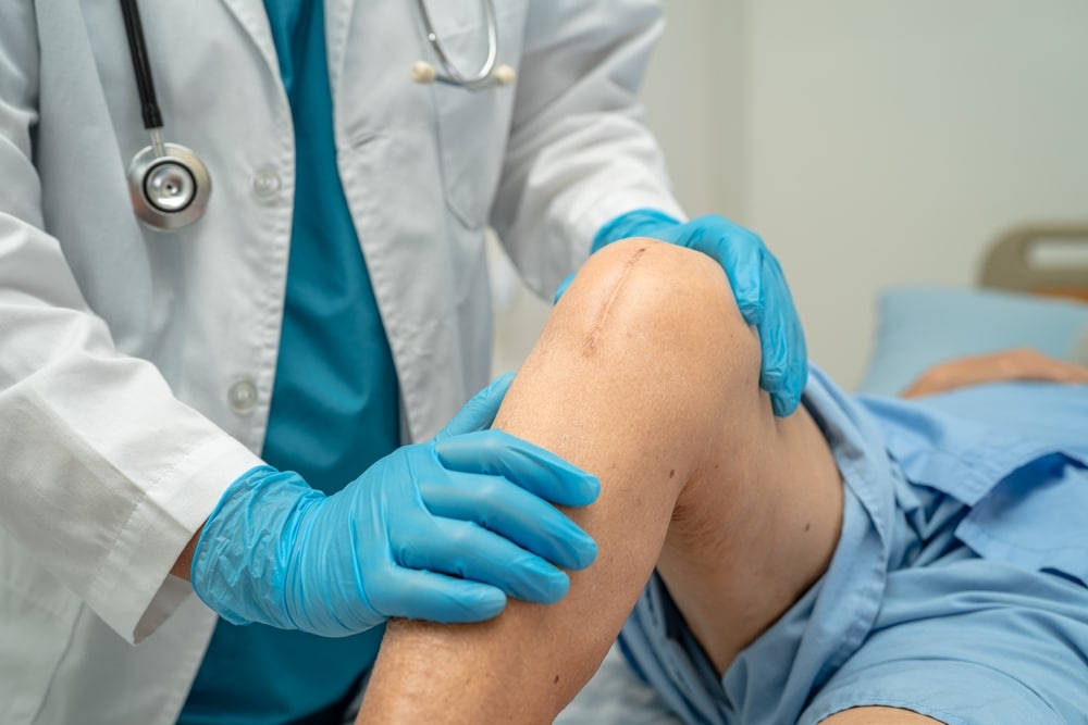 Doctor touches patients knee, but the injury was not corrected correctly with surgery.