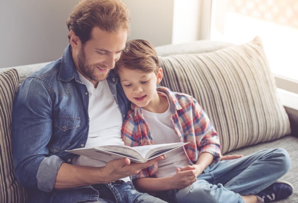A man reads a book to a child